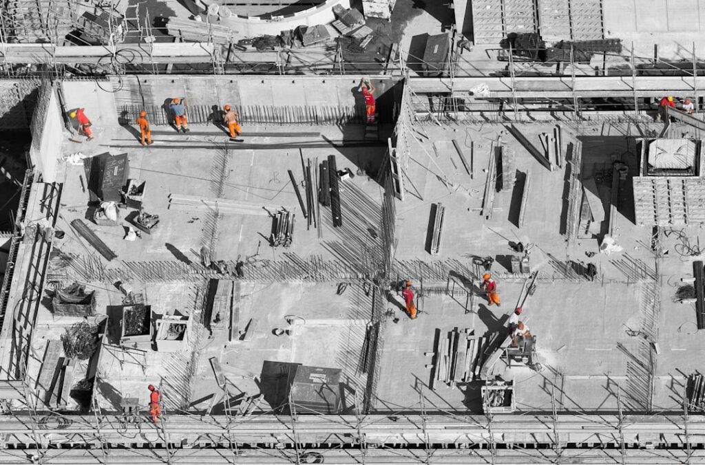 Technicians reviewing a 3D building model on a large screen in a construction planning room.