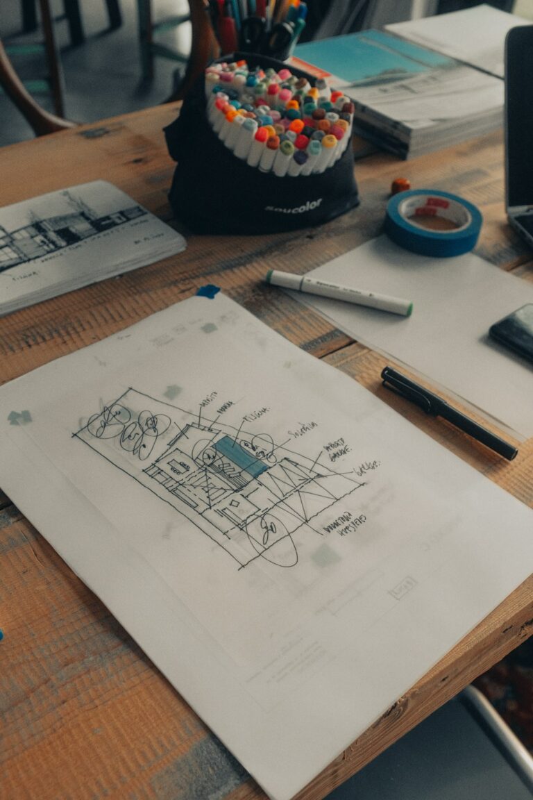 A skilled worker reviews mechanical drawings with pipes and ductwork in a building under renovation.