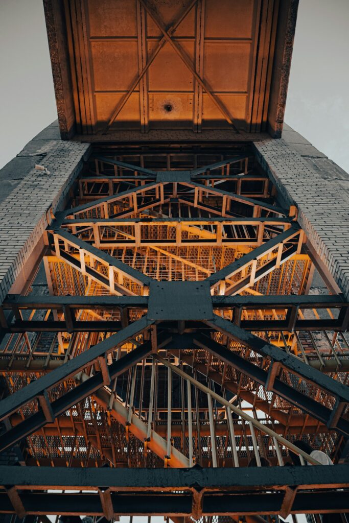 Technicians examining a digital 3D model of building mechanical systems on a large computer screen.